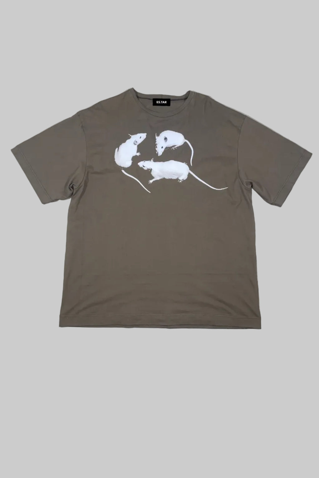 A brown short-sleeve t-shirt with a white graphic of three rats on the front, laid flat on a white wooden plank background.