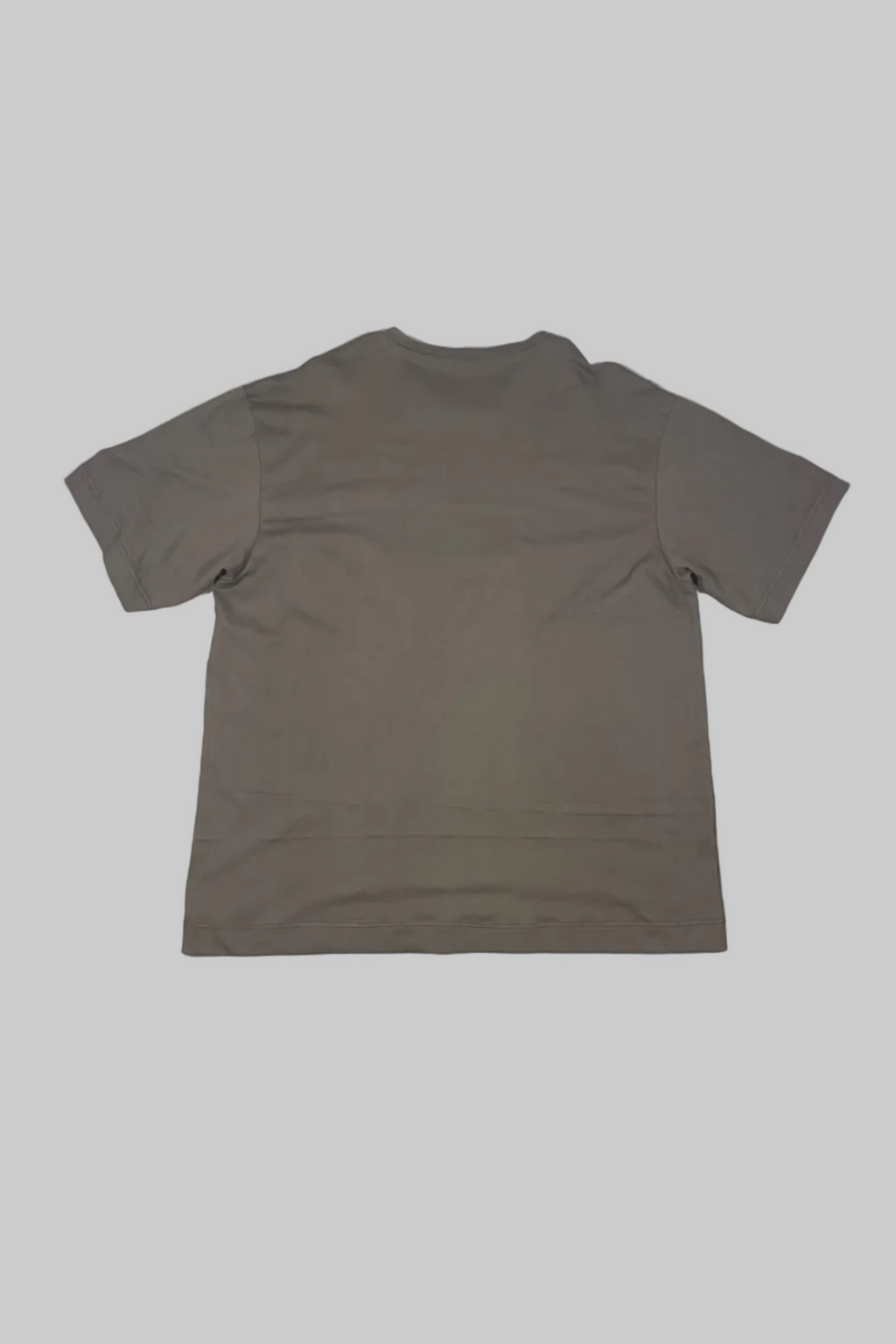 A plain taupe brown short-sleeve t-shirt laid flat on a white painted wooden floor, showing the back view.