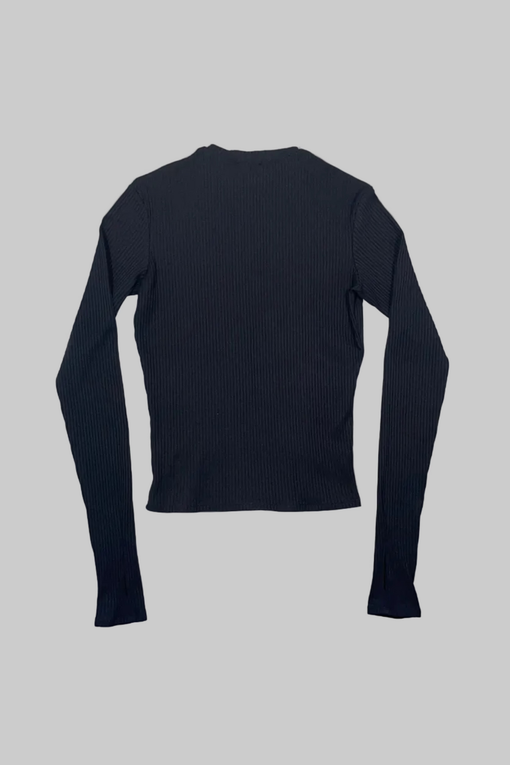 A black ribbed long-sleeve top laid flat on a white wooden plank surface.