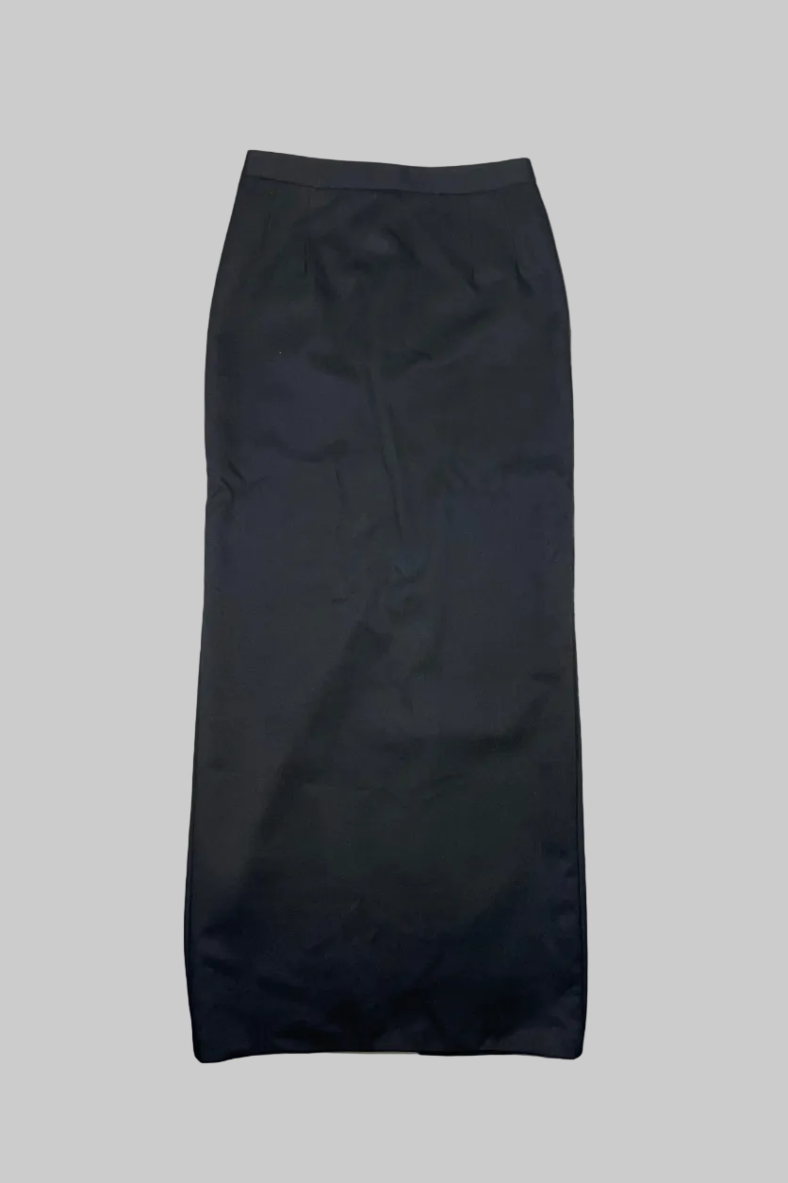 A dark charcoal gray pencil skirt laid flat on a white painted wooden floor.