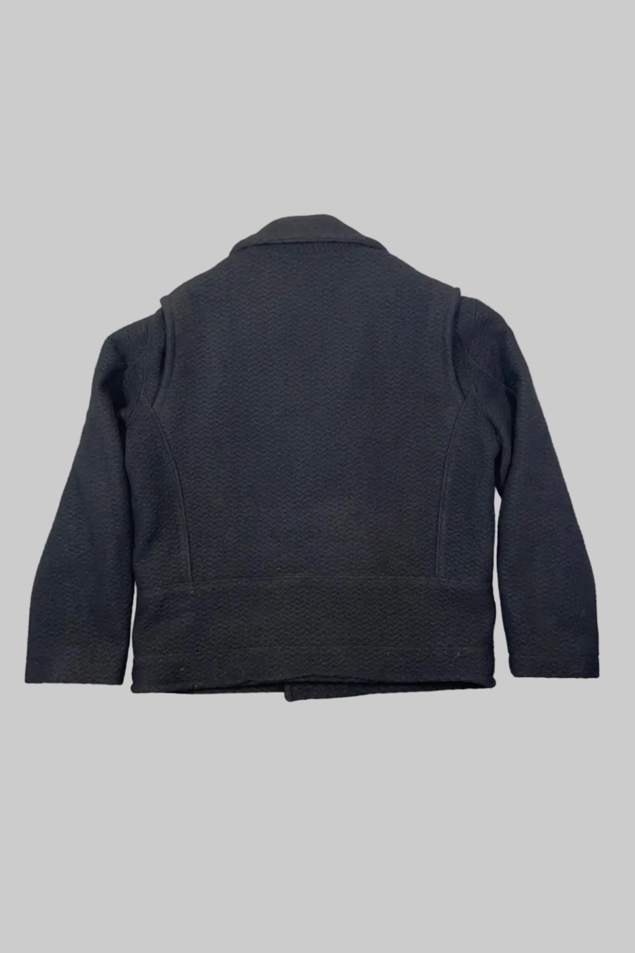 A dark charcoal gray textured jacket shown from the back, laid flat against a white painted wooden plank background.