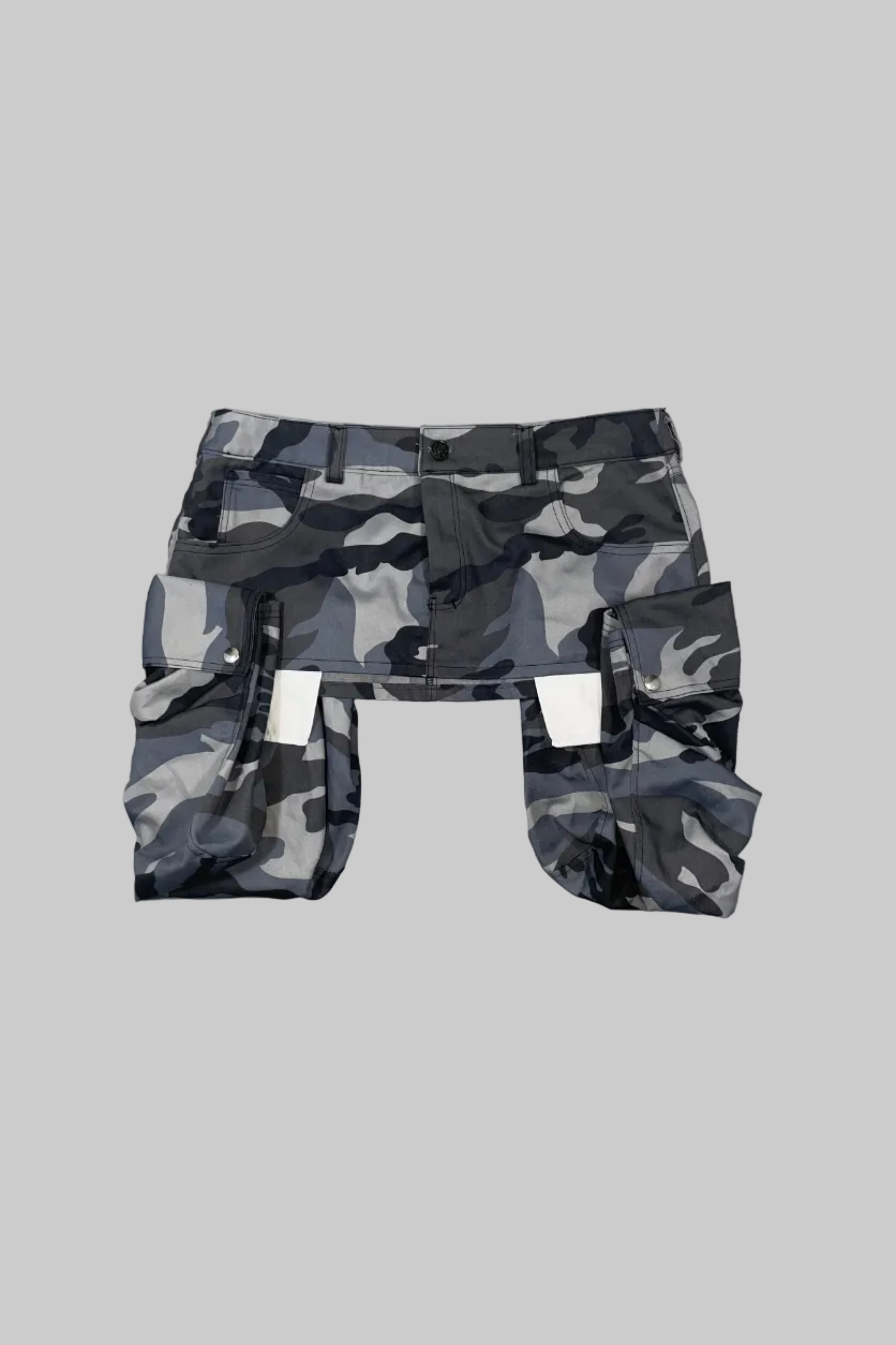 Gray and black camouflage cargo shorts with a matching belt, laid flat on a white wooden floor.
